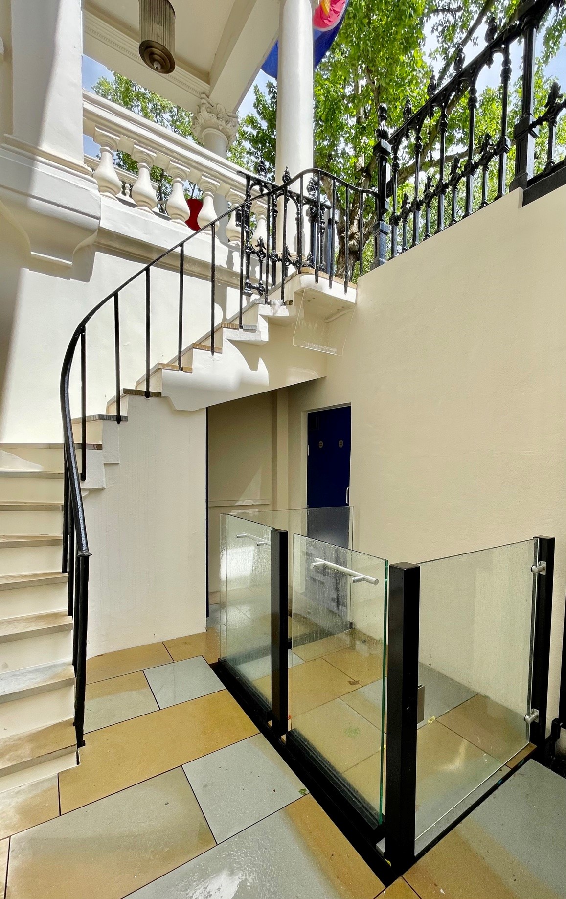 Lightwell platform lift below a curved external staircase