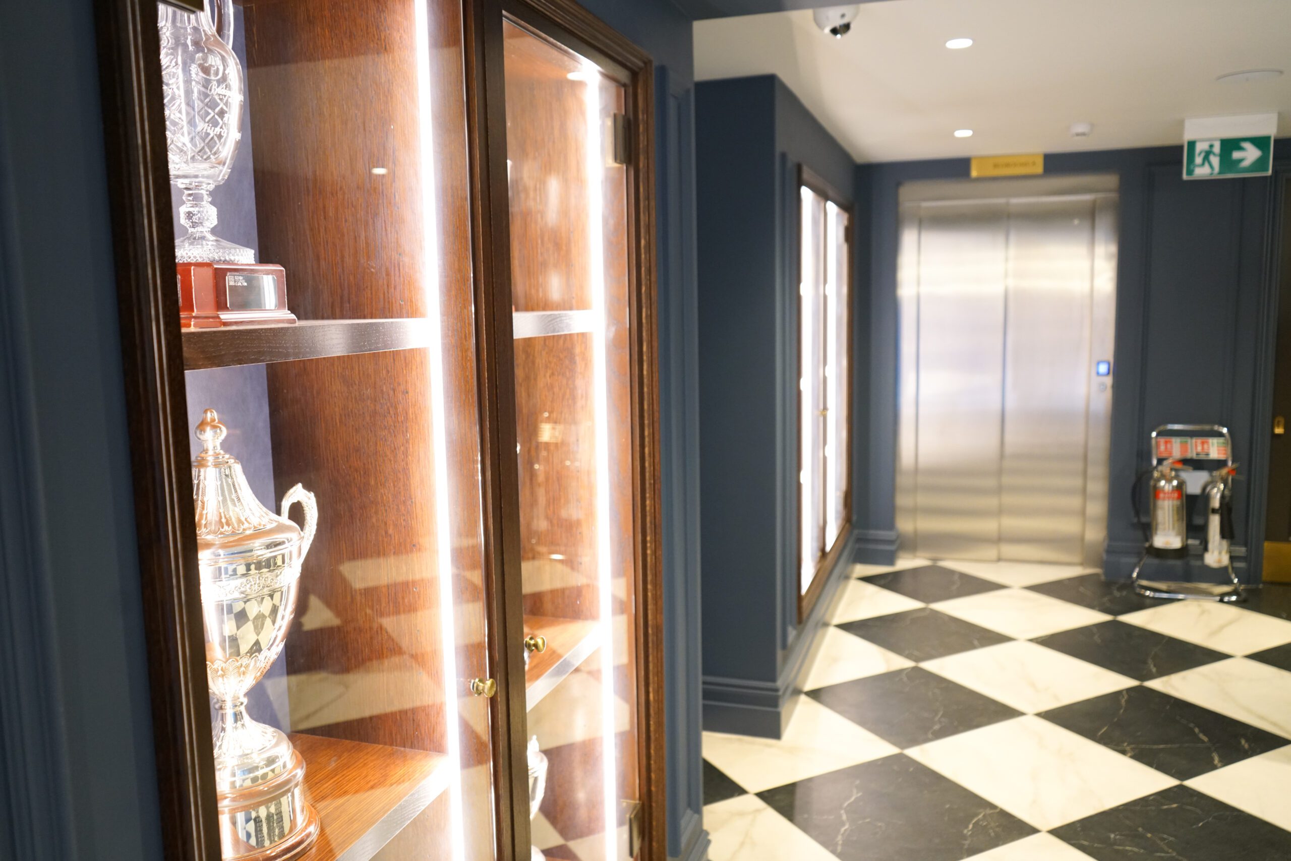 Cabin lift in a clubhouse hallway with a chequered floor