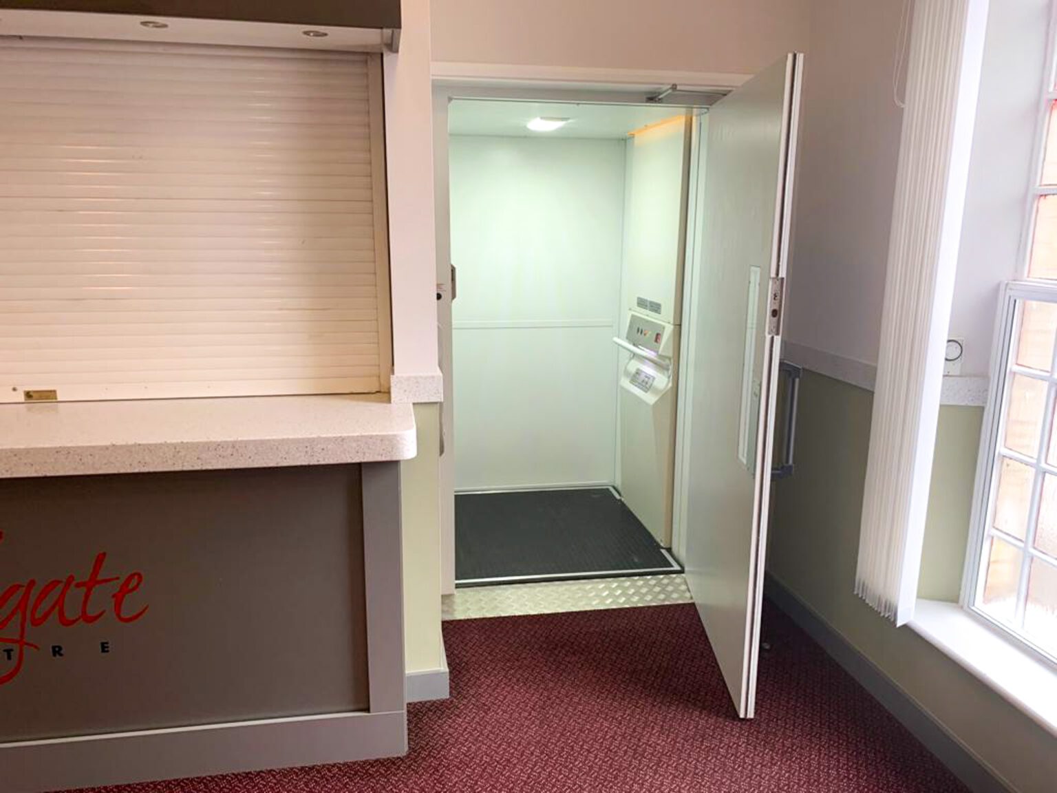 Platform lift with door open in a theatre foyer