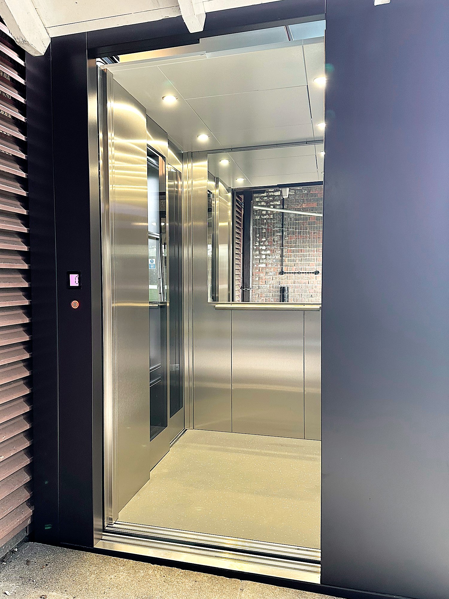 Cabin lift with stainless steel interior in an external glazed tower