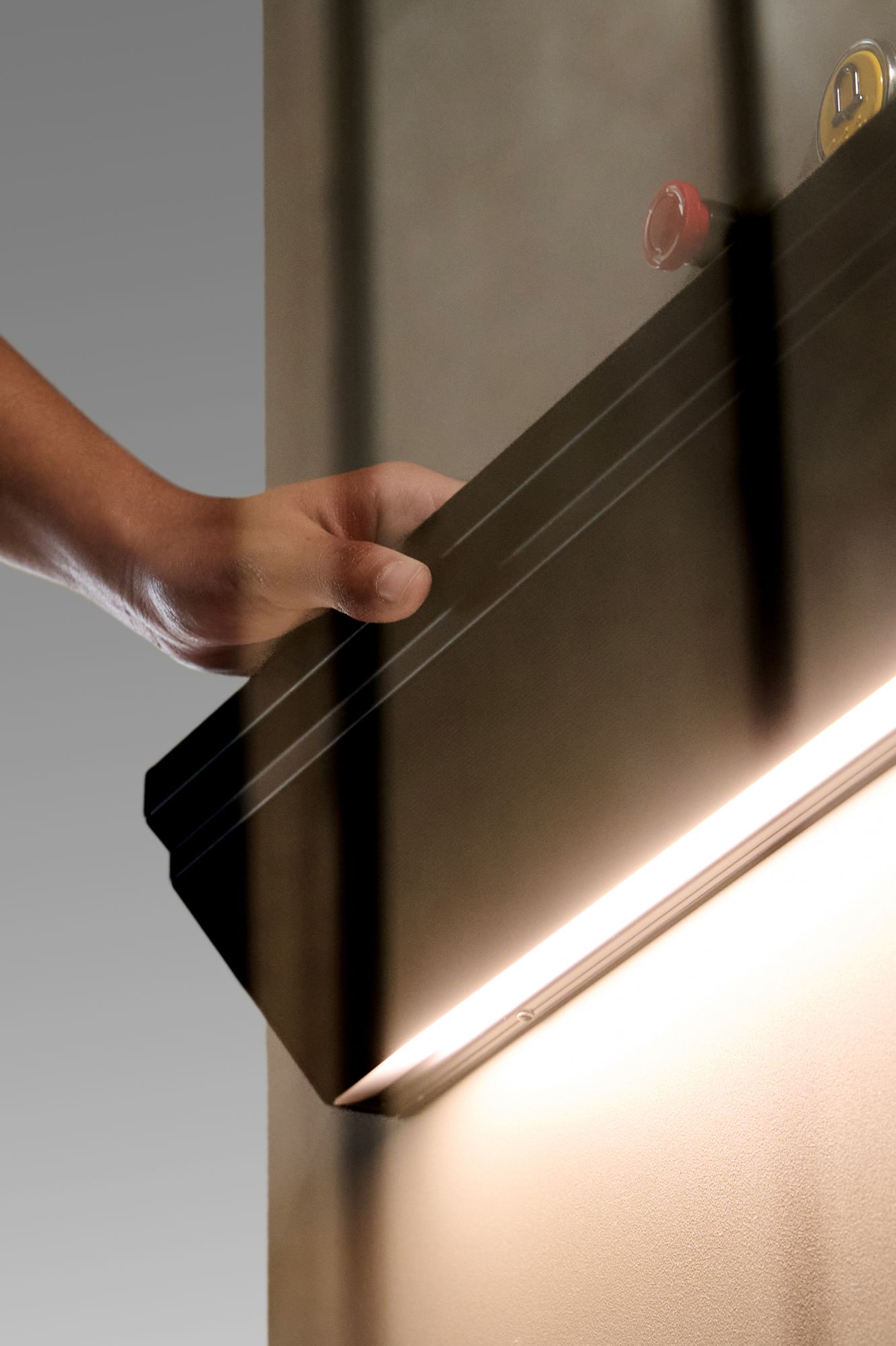 Hand touching the illuminated, touch-sensitive handrail of the APL Home Lift