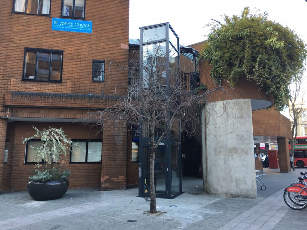 Hydraulic platform lift in an external glazed tower
