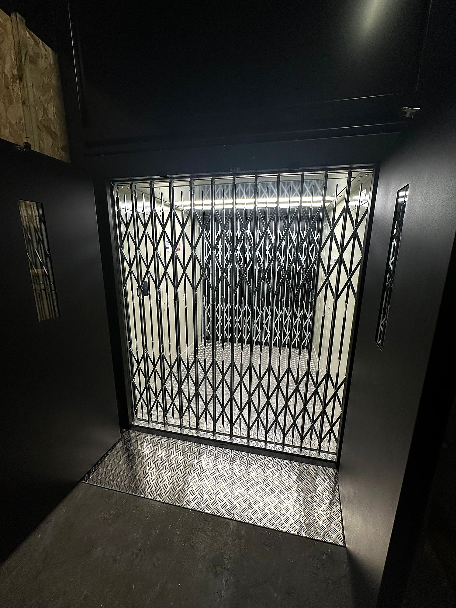 Traction goods lift with folding shutter gate