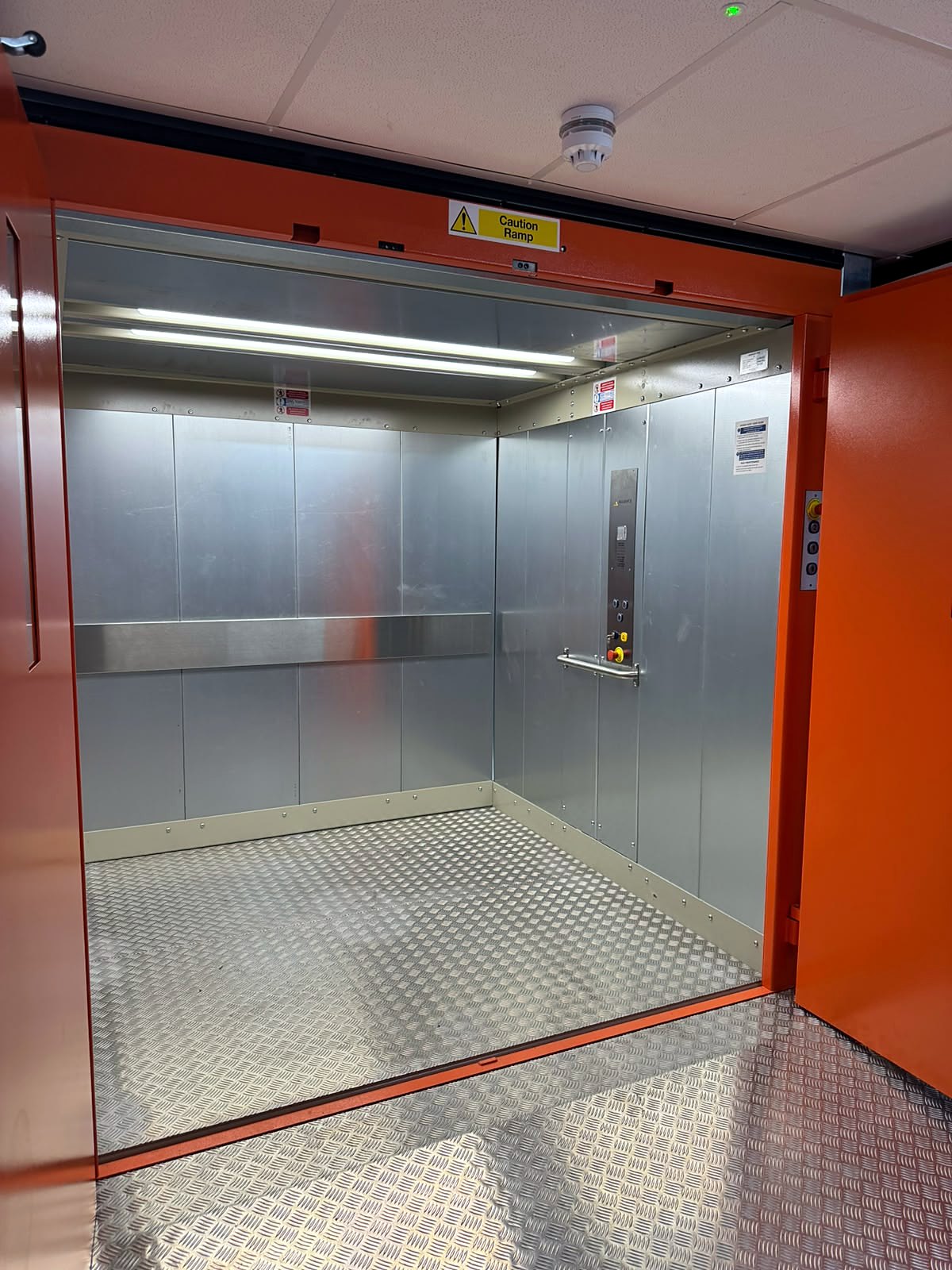 Traction goods lift car interior with chequer plate floor