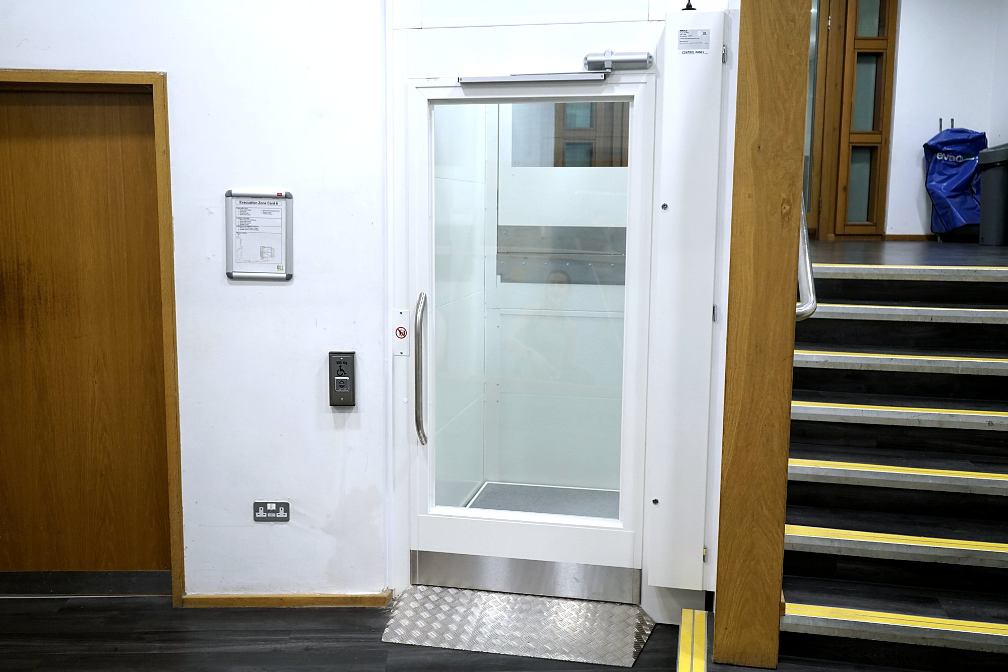 Chain-driven platform lift beside a staircase in a leisure centre